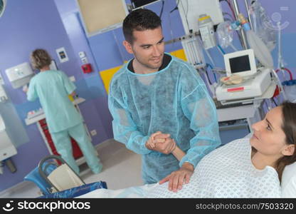 Husband holding wife's hand in delivery suite