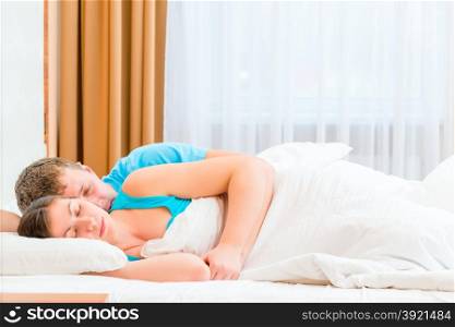 husband tenderly embracing his beloved wife in bed