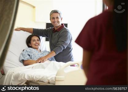 Husband Visiting Wife In Hospital And Talking To Nurse