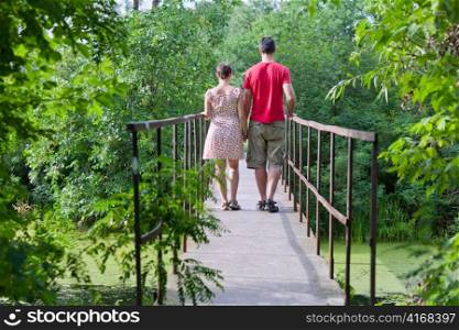 Husband with his wife on the bridge in green forest