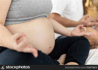 husbands and wives who are pregnant with living yoga on the white bedroom baby health love care concept selective focus