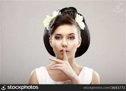 Hush! Beautiful Young Woman showing Silence Sign with her Forefinger. Warning