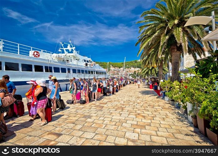 Hvar, Croatia, August 25, 2014: Hvar island harbor tourist queue. People waiting in line to board speedboat. Hvar is famous tourist destination, overcrowded by tourists in summenr months.