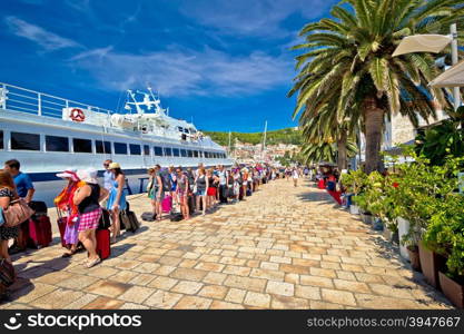 Hvar, Croatia, August 25, 2014: Hvar island harbor tourist queue. People waiting in line to board speedboat. Hvar is famous tourist destination, overcrowded by tourists in summenr months.