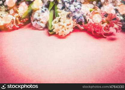 Hyacinths flowers border with bokeh on pink background
