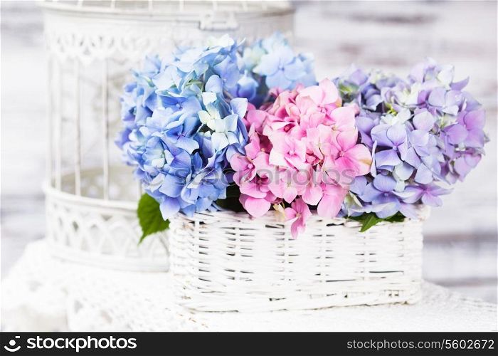 Hydrangea flowers in the white basket. Flower decor for the home