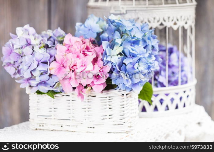 Hydrangea flowers in the white basket. Flower decor for the home. Hydrangea flowers