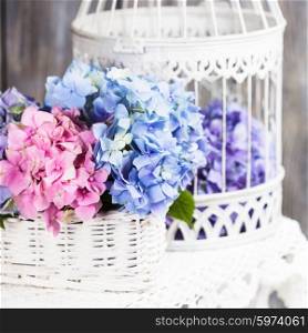 Hydrangea flowers in the white basket. Flower decor for the home. Hydrangea flowers