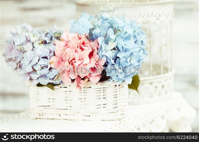 Hydrangea flowers in the white basket. Flower decor for the home. The hydrangea flowers