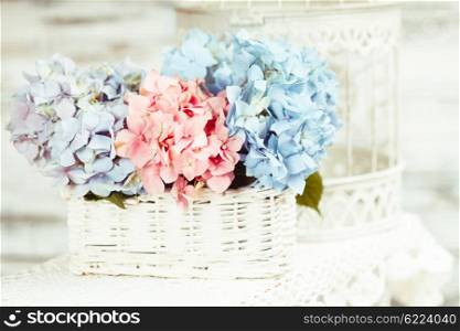 Hydrangea flowers in the white basket. Flower decor for the home. The hydrangea flowers