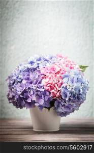 Hydrangea flowers in the white bucket on the wooden table