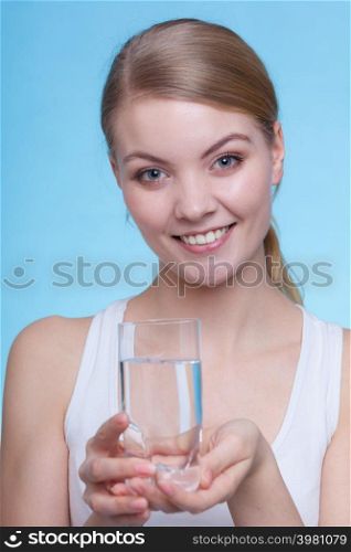 Hydration, healthy diet, drinking concept. Woman holding a glass of water, studio shot on blue background.. Woman holding a glass of water