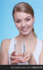 Hydration, healthy diet, drinking concept. Woman holding a glass of water, studio shot on blue background.. Woman holding a glass of water