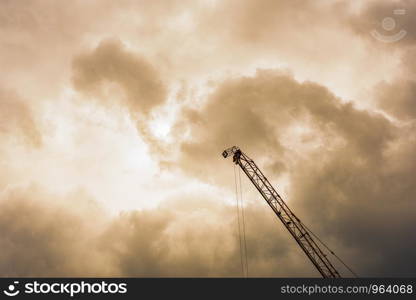 Hydraulic Mobile Crane against the elephant shaped cloud during sunset.