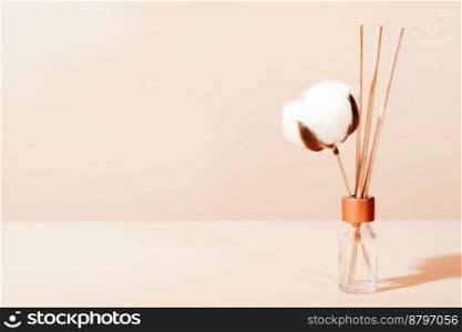  hygge and aromatherapy concept. aroma reed diffuser, branch of cotton. minimal style composition. winter and autumn mood..  hygge and aromatherapy concept. aroma reed diffuser, branch of cotton. minimal style composition. winter and autumn mood