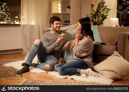 hygge, holidays and people concept - happy couple with gift box at home. happy couple with gift box at home
