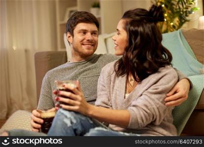 hygge, leisure and people concept - happy couple drinking coffee and eating at home. happy couple drinking coffee and eating at home