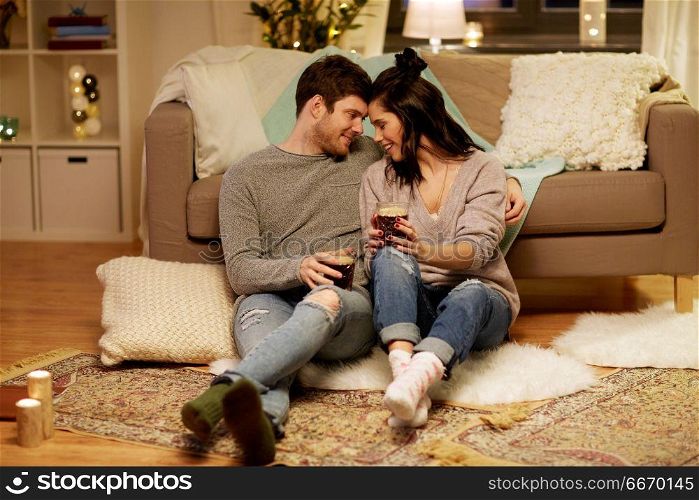 hygge, leisure and people concept - happy couple drinking coffee and eating at home. happy couple drinking coffee and eating at home. happy couple drinking coffee and eating at home