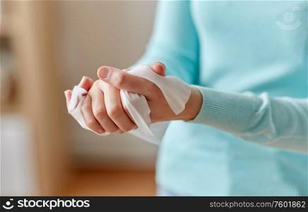 hygiene, health care and disinfection concept - close up of woman cleaning hands with antiseptic wet wipe. woman cleaning hands with antiseptic wet wipe