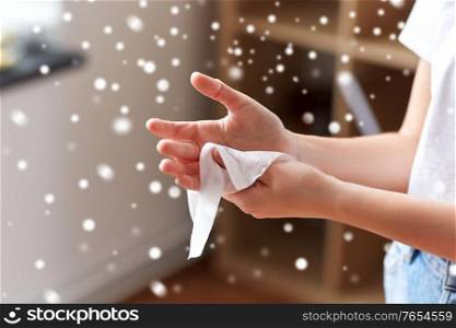hygiene, health care and disinfection concept - close up of woman cleaning hands with antiseptic wet wipe in winter over snow. woman cleaning hands with antiseptic wet wipe