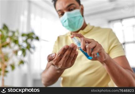 hygiene, health care and safety concept - close up of indian man wearing protective medical mask applying antibacterial hand sanitizer. close up of man in mask applying hand sanitizer