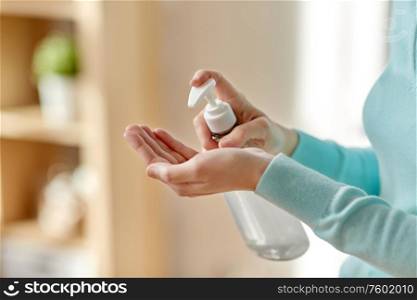 hygiene, health care and safety concept - close up of woman applying antibacterial hand sanitizer. close up of woman applying hand sanitizer