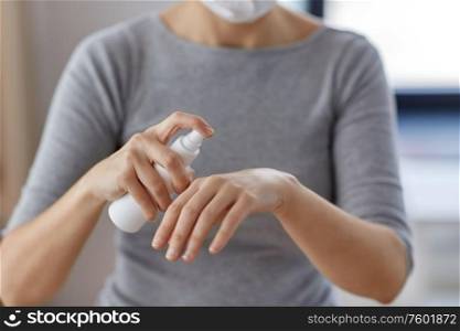 hygiene, health care and safety concept - close up of woman spraying antibacterial hand sanitizer. close up of woman spraying hand sanitizer