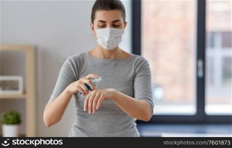 hygiene, health care and safety concept - close up of woman wearing protective medical mask spraying antibacterial hand sanitizer. close up of woman in mask spraying hand sanitizer