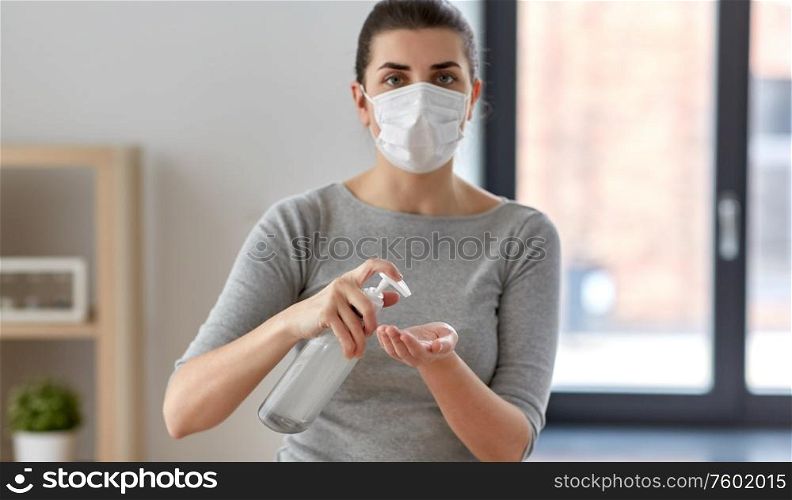hygiene, health care and safety concept - close up of woman wearing protective medical mask applying antibacterial hand sanitizer. close up of woman in mask applying hand sanitizer