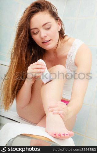 Hygiene skin body care concept. Hair removal. woman shaving legs with electric shaver depilator in bathroom