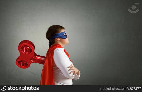 Hyperactive super child. Little super active boy with key on back wearing super hero costume