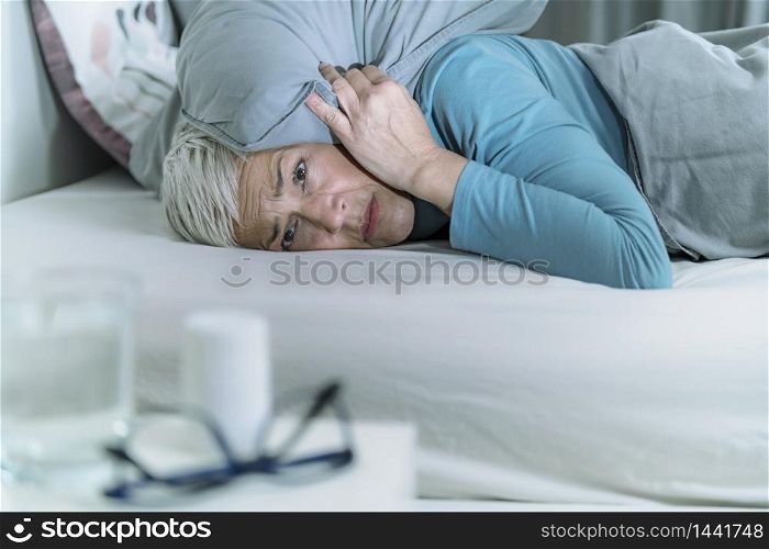 Hyperacusis Disorder. Mature Woman Suffering From Hyperacusis, Fear of Sounds Holding Pillow Over Her Head