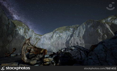 hyperlapse of night starry sky with mountain and ocean beach in Lofoten Norway