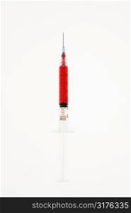 Hypodermic needle filled with red liquid on white background.