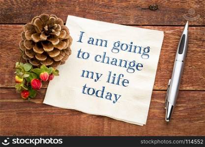 I am going to change my life today - inspiraitonal handwriting on a napkin against rustic wood