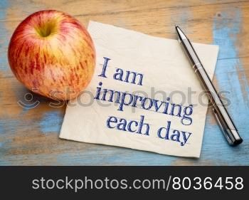 I am improving each day - self development concept or positive affirmation - handwriting on a napkin with an apple