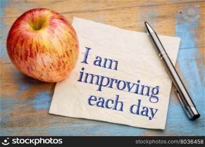 I am improving each day - self development concept or positive affirmation - handwriting on a napkin with an apple
