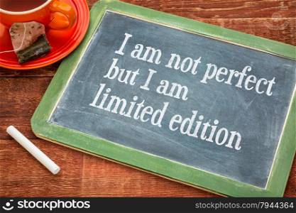I am not perfect but I am limited edition - individuality concept on a slate blackboard with chalk and cup of tea