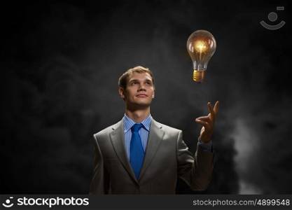 I have an idea. Young businessman pointing with finger at glowing light bulb