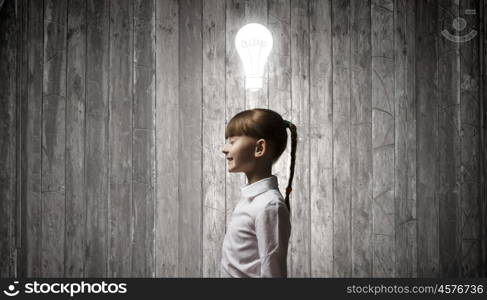 I have bright idea. Side view of girl of school age and light bulb above her head