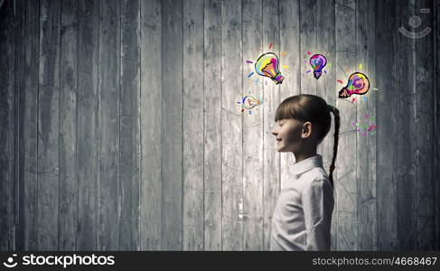 I have bright idea. Side view of girl of school age and light bulb above her head