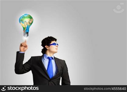 I have idea. Image of young businessman with light bulb. New idea and inspiration. Elements of this image are furnished by NASA