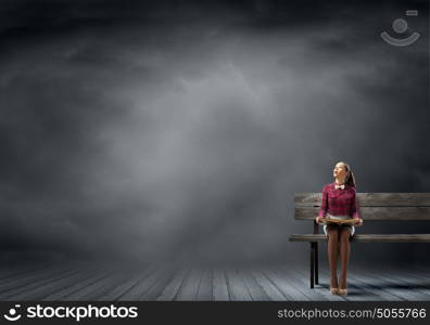 I like reading!. Young beautiful lady sitting on bench and reading book