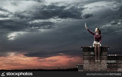 I like reading!. Young beautiful lady sitting on building roof and reading book