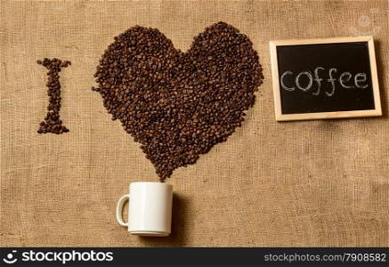 ""I love coffee" spelled by coffee beans, coffee mug and chalk board"