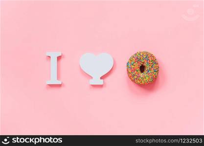 I love donuts concept. Multi-colored donut and white heart on a pink background. Top view Creative Flat lay Copy space. Template for your design.. I love donuts concept. Multi-colored donut and white heart on a pink background. Top view Creative Flat lay Copy space. Template for your design