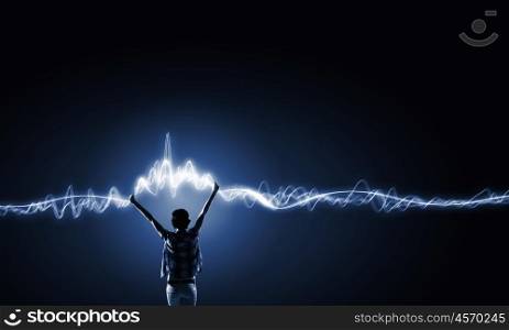 I love music. Back view of young girl in casual against dark background