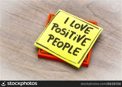 I love positive people - handwriting on a sticky note against grained wood