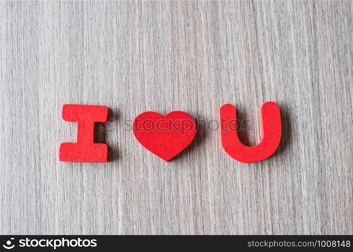 I Love U word of wooden alphabet letters with red heart shape on table background. Romance, Romantic and Valentine's day concepts