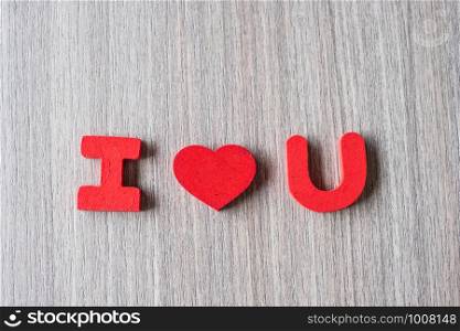 I Love U word of wooden alphabet letters with red heart shape on table background. Romance, Romantic and Valentine's day concepts
